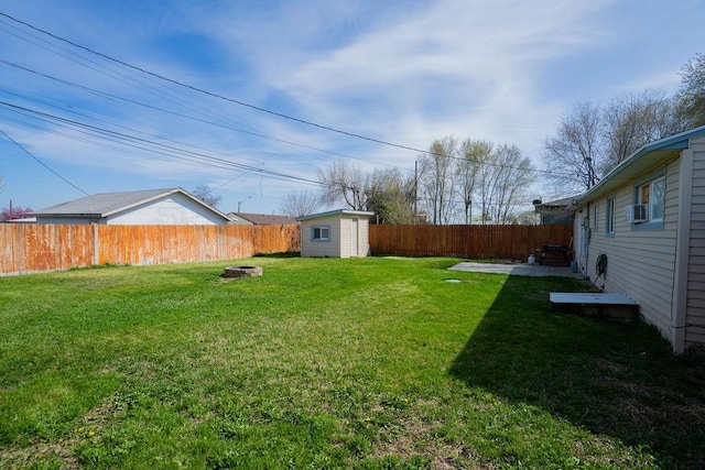 view of yard with a shed, a fenced backyard, and an outbuilding