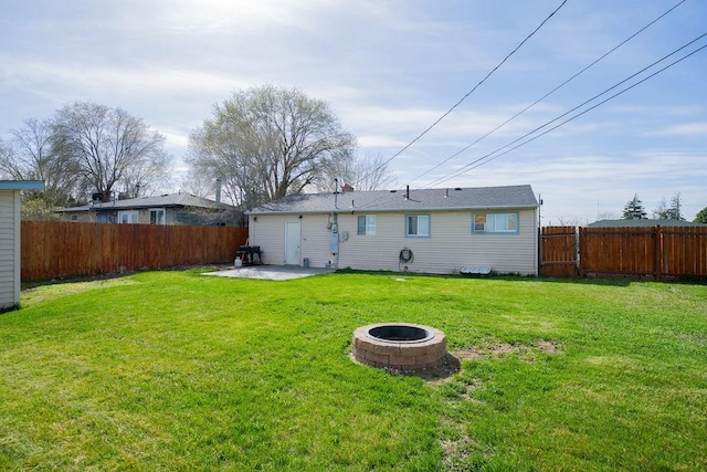 back of property featuring a patio area, a fenced backyard, a fire pit, and a lawn
