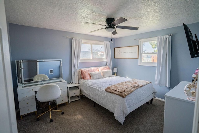 bedroom with a ceiling fan, carpet, and a textured ceiling