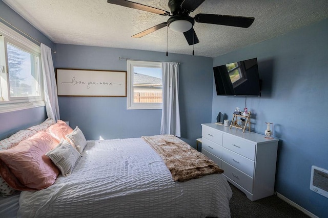 bedroom featuring carpet, multiple windows, a textured ceiling, and ceiling fan