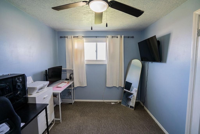 office space with baseboards, a ceiling fan, dark colored carpet, and a textured ceiling