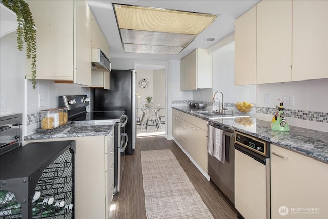 kitchen featuring dark wood finished floors, tasteful backsplash, stainless steel appliances, and a sink