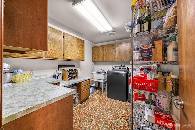 9652 Ronald Dr, Blaine, WA 98230 - kitchen with brown cabinetry, light countertops, washer / clothes dryer, and visible vents