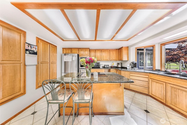 9652 Ronald Dr, Blaine, WA 98230 - kitchen with a breakfast bar area, a center island, a sink, freestanding refrigerator, and dark stone counters