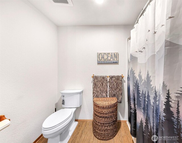 9652 Ronald Dr, Blaine, WA 98230 - full bathroom with visible vents, wood finished floors, baseboards, toilet, and a shower with shower curtain