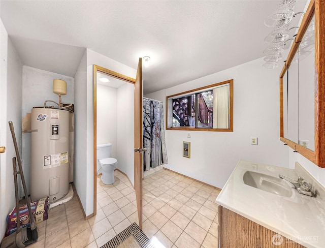 9652 Ronald Dr, Blaine, WA 98230 - full bath featuring tile patterned floors, baseboards, vanity, toilet, and water heater