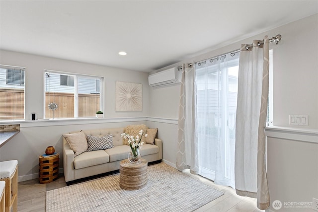 8015 Beacon Ave S Unit A, Seattle, WA 98118 - living room featuring light wood-style floors, a wall unit AC, baseboards, and recessed lighting