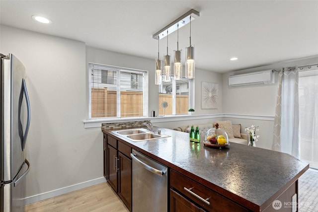 8015 Beacon Ave S Unit A, Seattle, WA 98118 - kitchen with light wood-type flooring, a wall unit AC, dark countertops, a sink, and stainless steel appliances