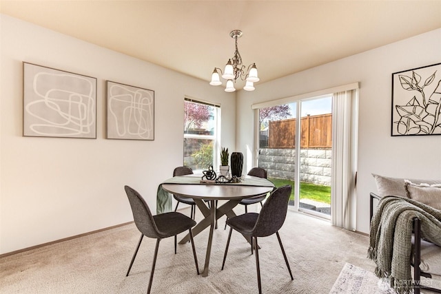 dining space with a chandelier, light carpet, and baseboards