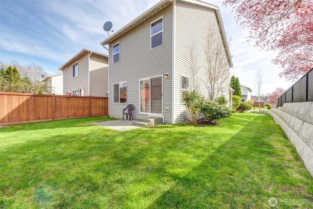rear view of house with a patio, a fenced backyard, and a lawn