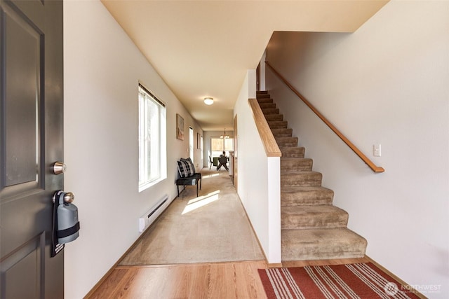 entryway with light wood-style flooring, a baseboard radiator, and stairway