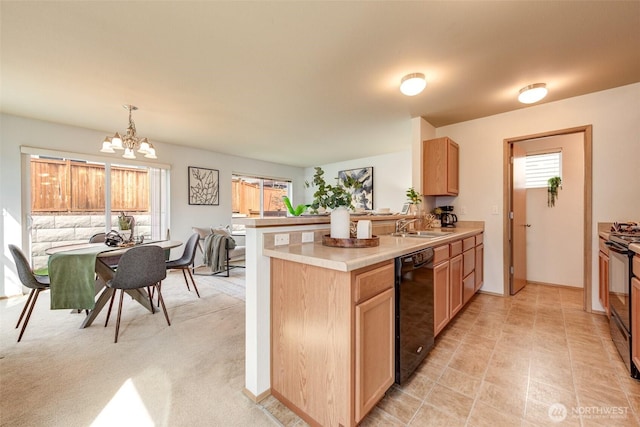 kitchen featuring black appliances, plenty of natural light, a notable chandelier, and a peninsula