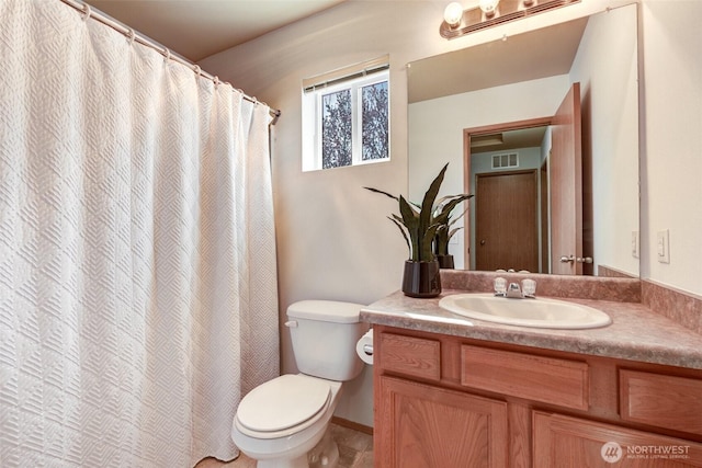 full bathroom featuring toilet, vanity, and visible vents