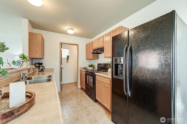 kitchen featuring a sink, light countertops, light brown cabinetry, under cabinet range hood, and black appliances