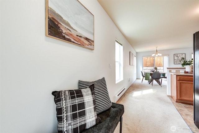hallway with light colored carpet, a baseboard heating unit, and a notable chandelier