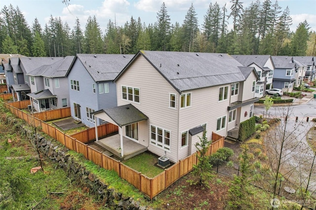 1332 247th Pl NE, Sammamish, WA 98074 - rear view of property featuring a fenced backyard, a shingled roof, cooling unit, and a residential view