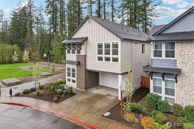 1332 247th Pl NE, Sammamish, WA 98074 - view of front facade with board and batten siding, roof with shingles, an attached garage, and concrete driveway