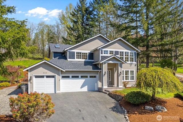 traditional-style house with a garage, roof with shingles, and driveway
