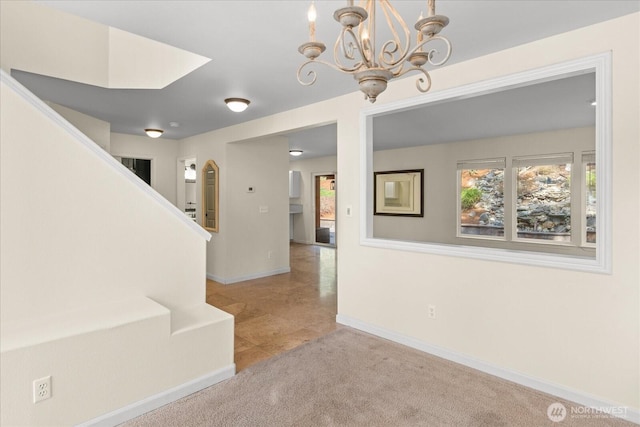 interior space featuring a chandelier, baseboards, carpet, and stairway