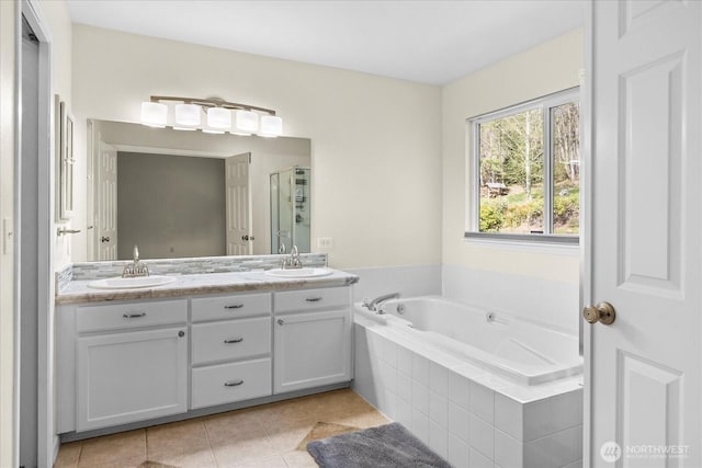 full bathroom with a shower stall, a garden tub, a sink, and tile patterned flooring