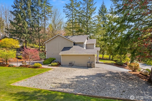 view of property exterior featuring a yard and roof with shingles