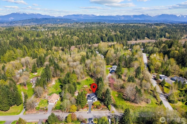 bird's eye view featuring a wooded view and a mountain view