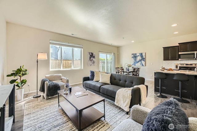 living area featuring recessed lighting, baseboards, and wood finished floors