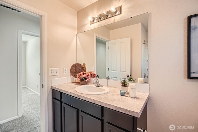 bathroom with baseboards, visible vents, and vanity