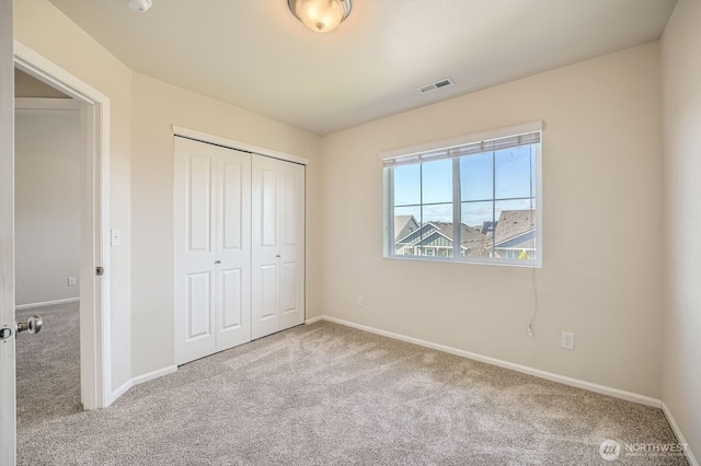 unfurnished bedroom with visible vents, carpet, baseboards, and a closet