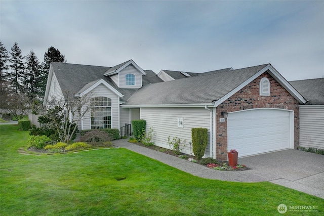 view of front of home featuring concrete driveway, roof with shingles, an attached garage, a front yard, and brick siding