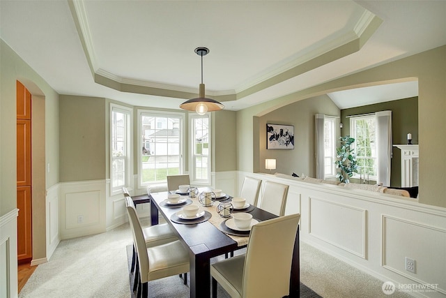 dining room featuring crown molding, a tray ceiling, and arched walkways
