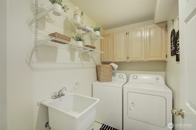 laundry area featuring separate washer and dryer, a sink, and cabinet space