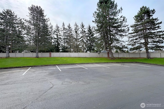 uncovered parking lot featuring fence