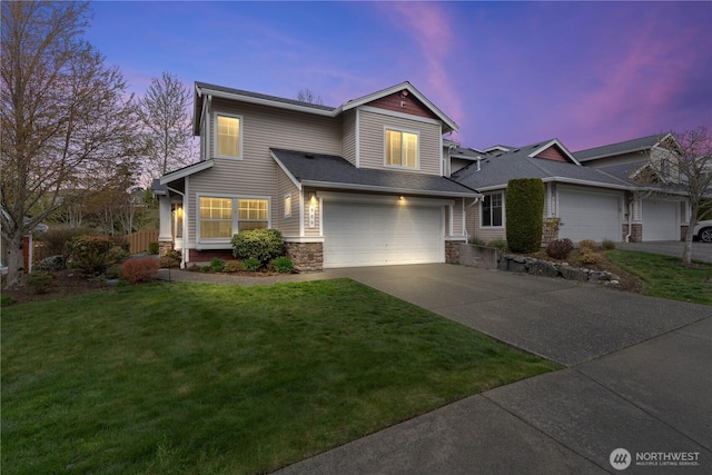 view of front of house featuring concrete driveway, a front yard, stone siding, and a garage