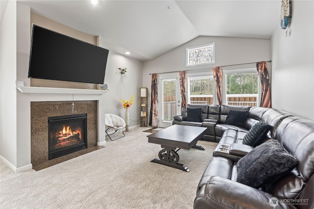 living area with a fireplace with flush hearth, lofted ceiling, baseboards, and carpet floors