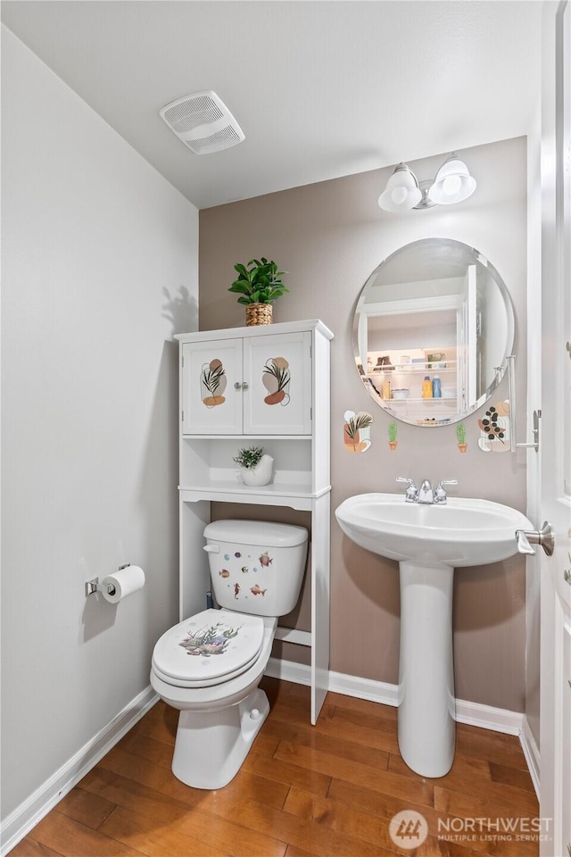bathroom with visible vents, baseboards, toilet, and wood finished floors