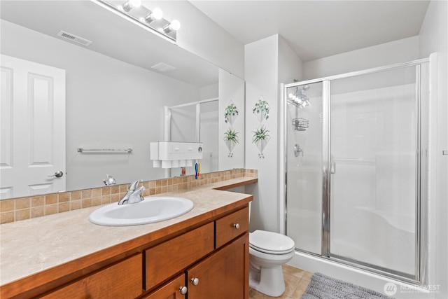bathroom with vanity, a stall shower, tile patterned floors, toilet, and visible vents