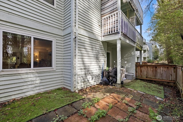 view of home's exterior with a balcony, fence, and a patio area