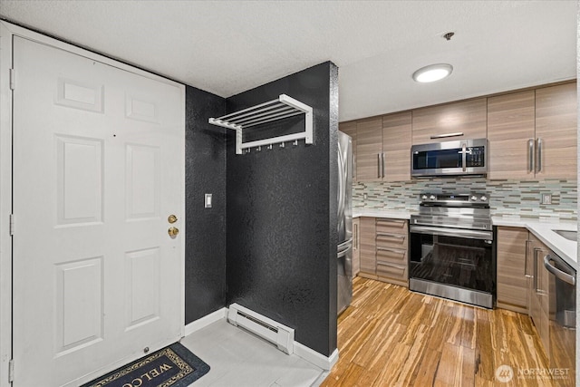 kitchen with stainless steel appliances, a baseboard heating unit, light countertops, brown cabinetry, and modern cabinets