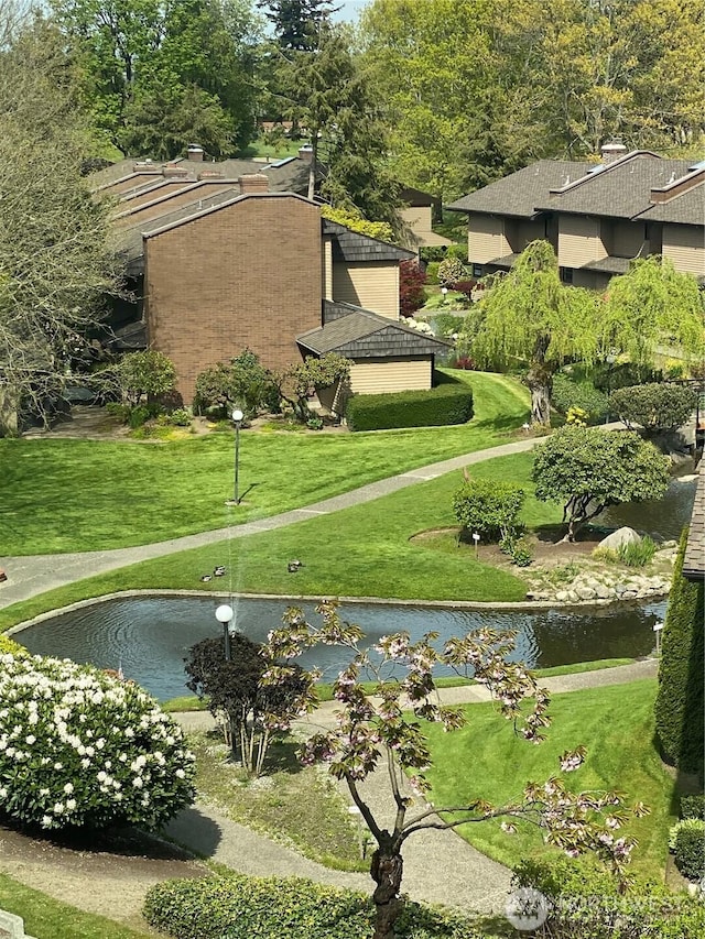 surrounding community featuring a lawn and a water view