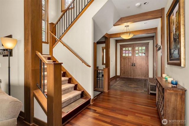 entrance foyer with baseboards, wood finished floors, and stairs