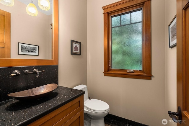 bathroom with vanity, backsplash, and toilet