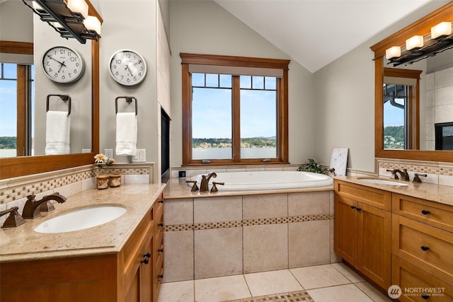 bathroom with tasteful backsplash, vaulted ceiling, a sink, and two vanities