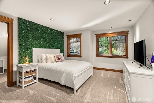 bedroom featuring baseboards, an accent wall, recessed lighting, wallpapered walls, and light carpet