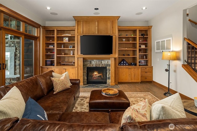 living area with baseboards, recessed lighting, stairway, a fireplace with flush hearth, and wood finished floors