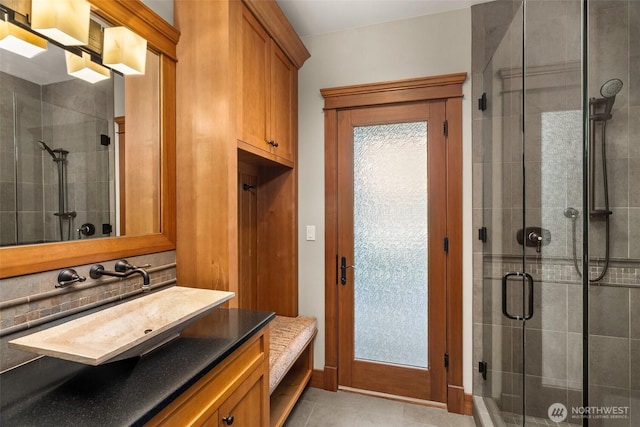 full bath with tile patterned flooring, vanity, and a stall shower
