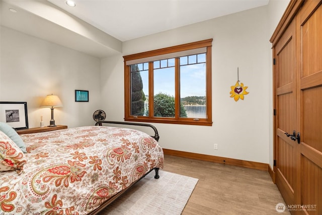 bedroom with light wood-type flooring and baseboards