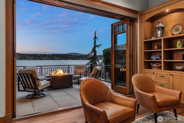 sitting room featuring a water view and wood finished floors
