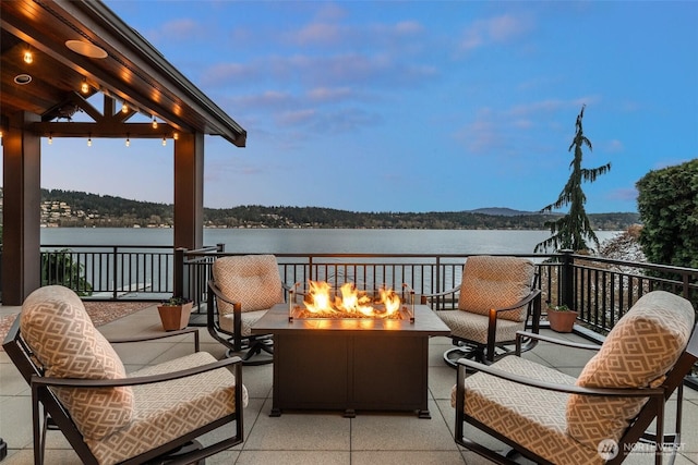 balcony featuring a water view and a fire pit