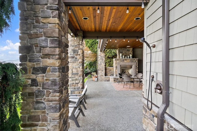 view of patio featuring an outdoor stone fireplace